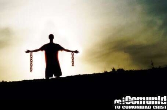 En la imagen en el horizonte un hombre con los brazos abiertos con cadenas rotas